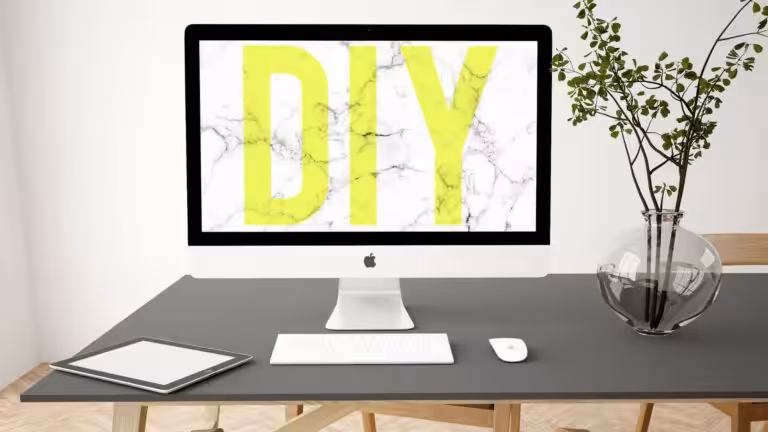 A desk set up with an iMac desktop that has "DIY" on the screen.