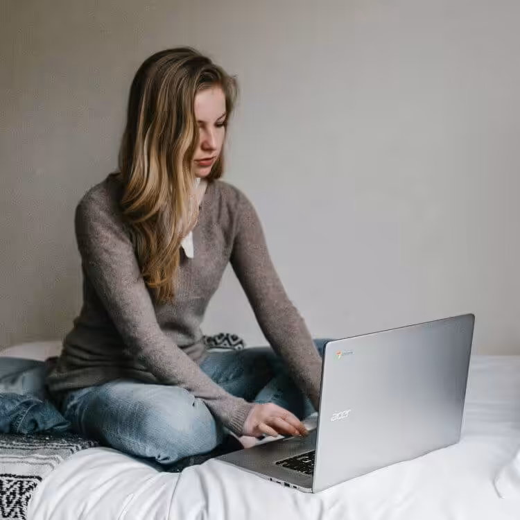 A photo of a woman working on their acer laptop