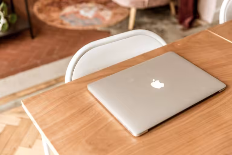Apple MacBook closd on a desk space.