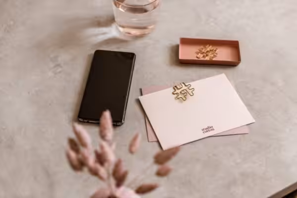 A workspace scene at the Studio Cotton design studio including notecards, paperclips and an iPhone