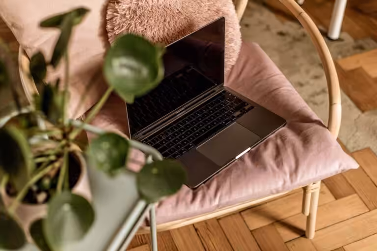 Laptop on a pink cushion inside Studio Cotton