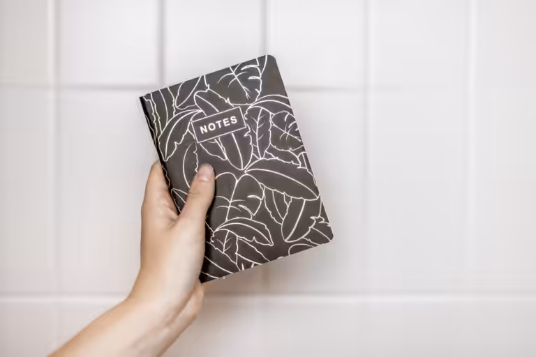 a hand holding up a notebook