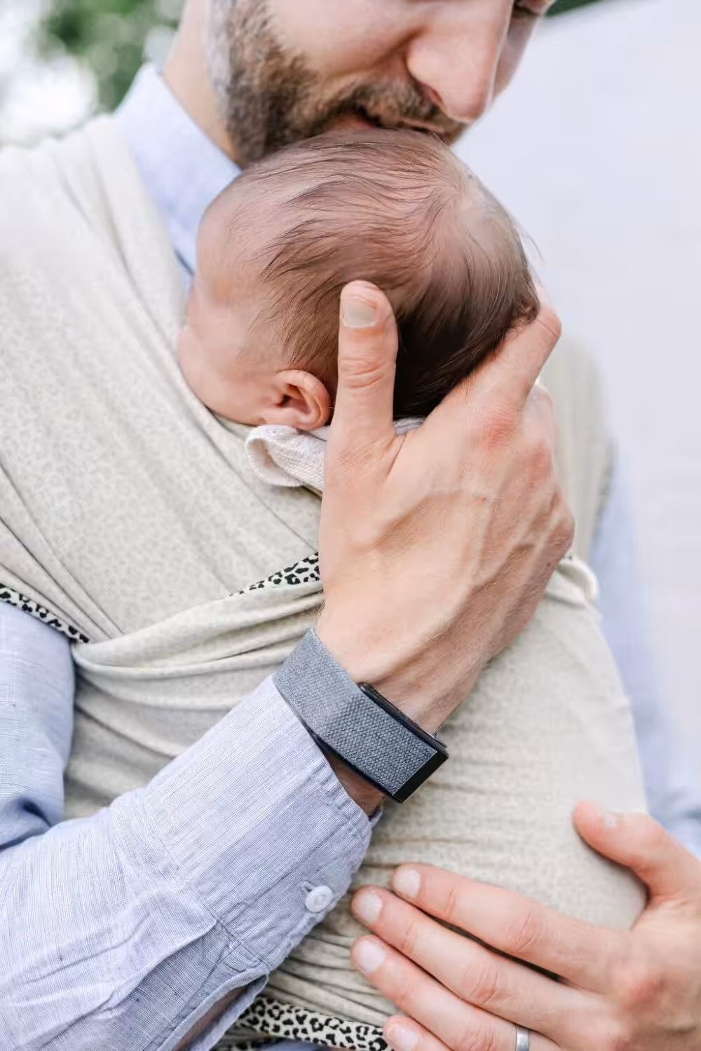 Man holding a baby in lovely small business Bon and Bear's sling wrap.