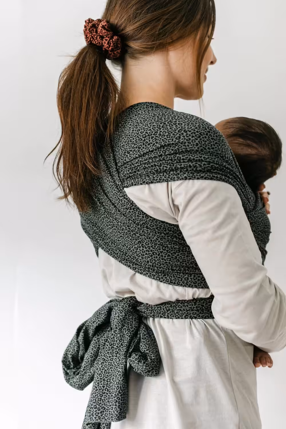 Woman holding a baby in lovely small business Bon and Bear's sling wrap.