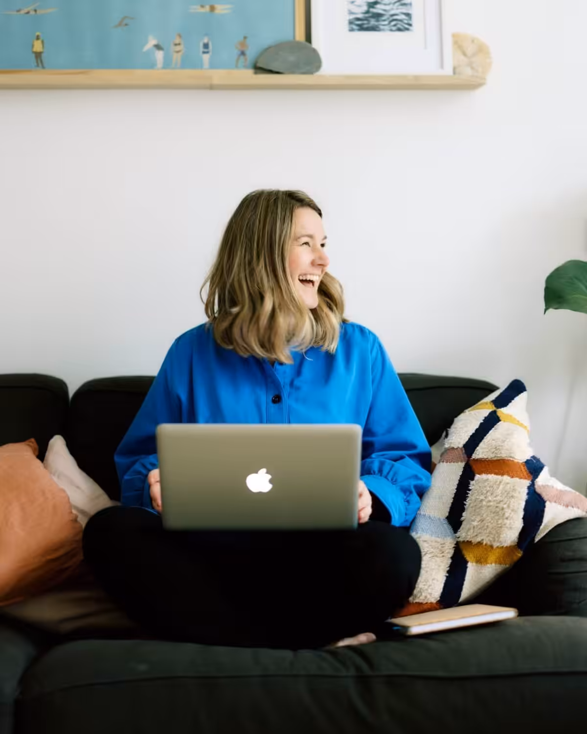 Jo McCarthy laughing on a sofa.