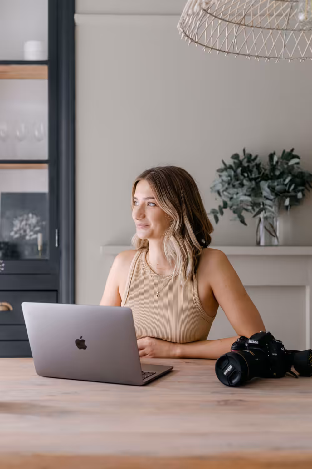 Photographer Weronika Karczewska at a macbook with her camera.