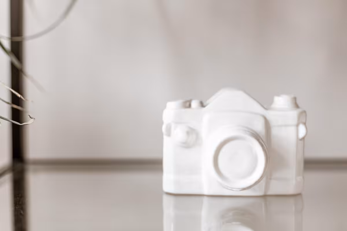 White ceramic model of a camera on a white background.