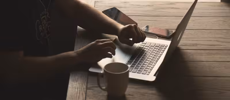 Someone at a laptop, making a great coffee shop website.