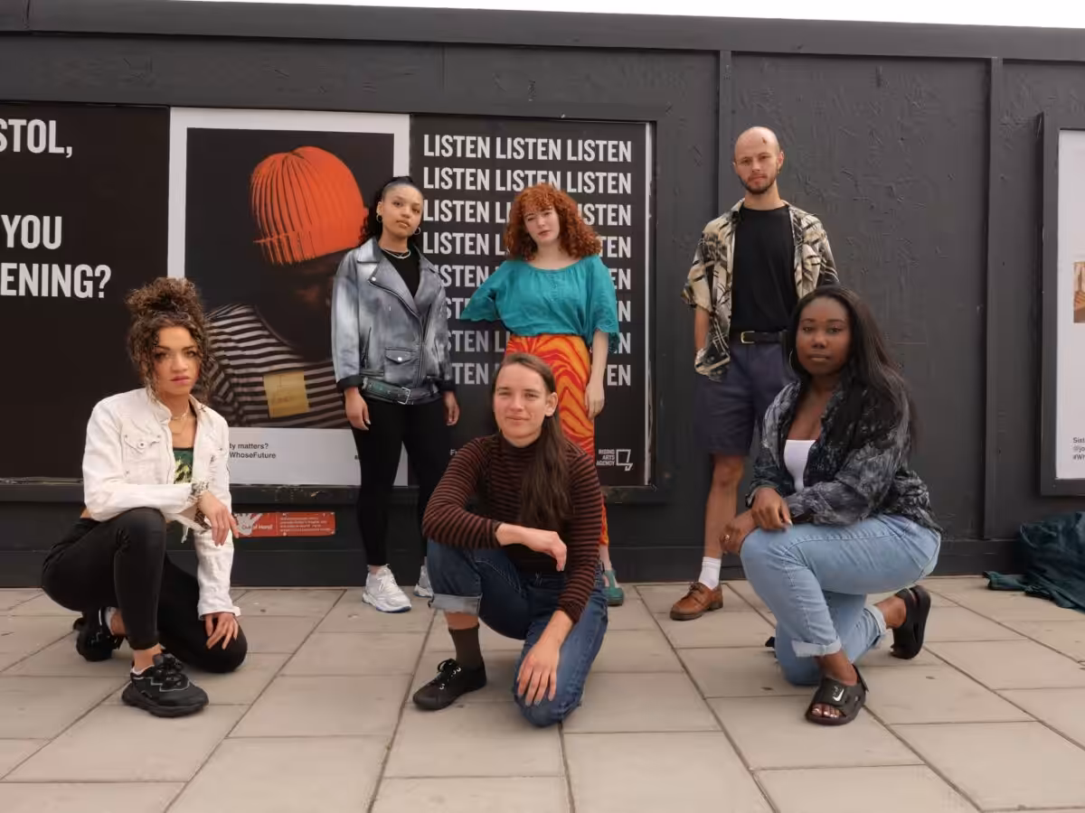 Rising Arts Team standing in front of their campaign posters.