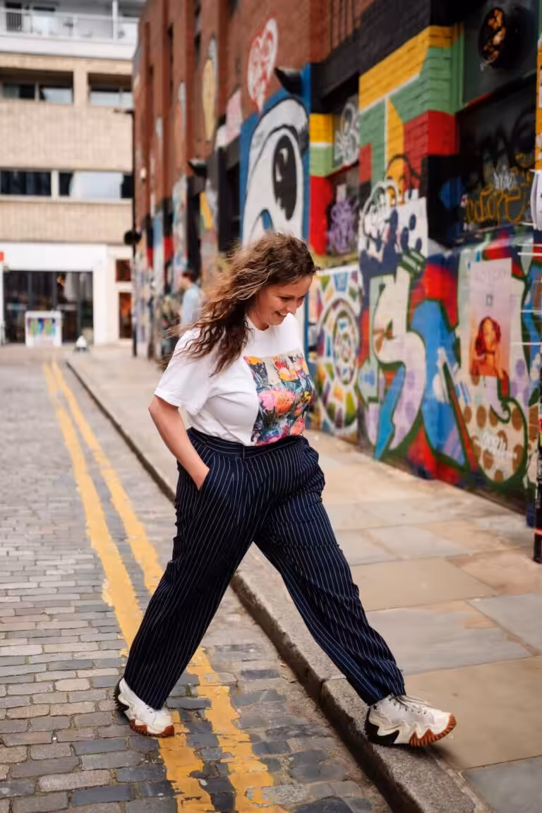 A photo of copywriter Ellie Kime walking in a colourful street
