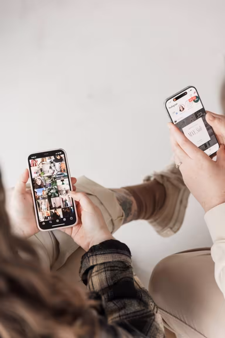 A close up of two Apple iPhones in the hands of Studio Cotton's Aime and Lyzi who are using Instagram.