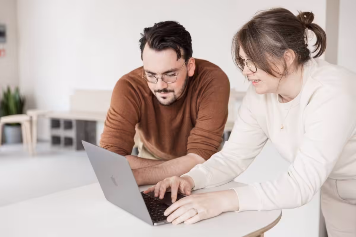 Studio Cotton's Aime and Cai working together on an Apple MacBook.