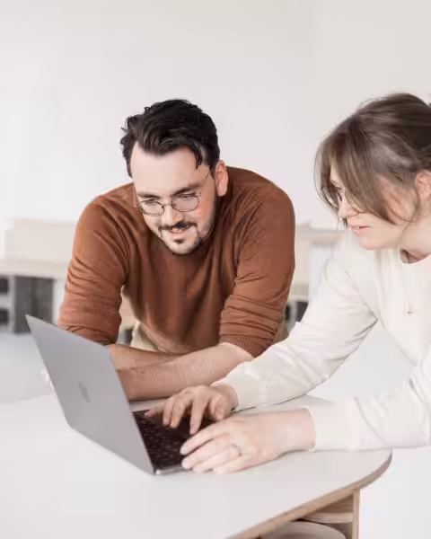 Studio Cotton's Aime and Cai working together on an Apple MacBook laptop.