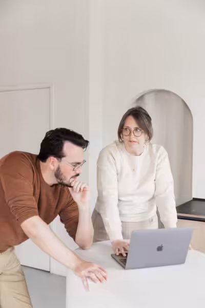 Studio Cotton's Aime and Cai using an Apple iMacBook laptop.