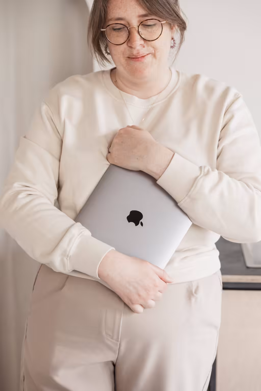Studio Cotton founder Aime clutching onto an Apple MacBook.