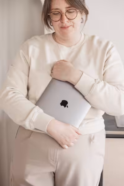 Studio Cotton founder Aime clutching onto an Apple MacBook.