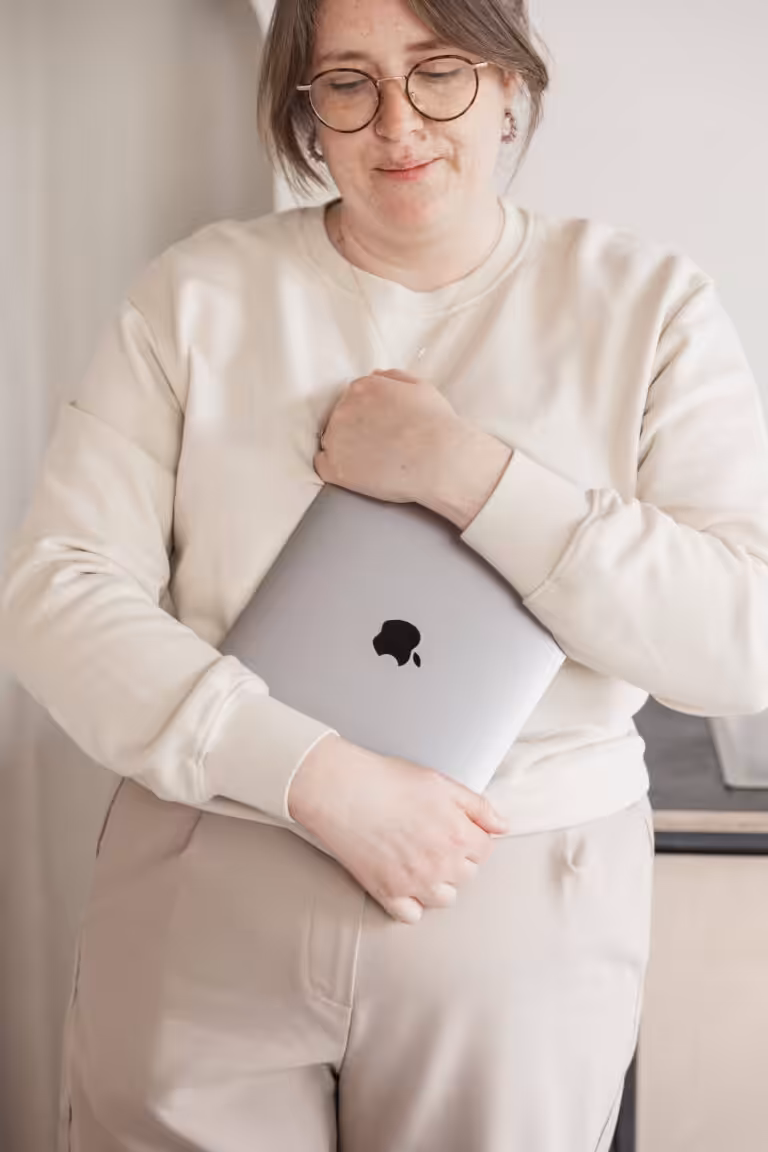 Studio Cotton founder Aime clutching onto an Apple MacBook.