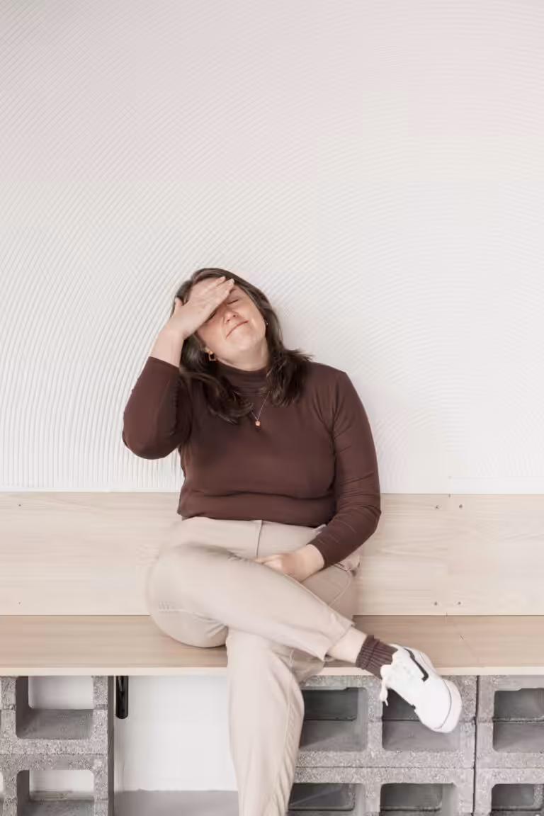 Studio Cotton founder Aime holding a hand up to her forehead with eyes closed.