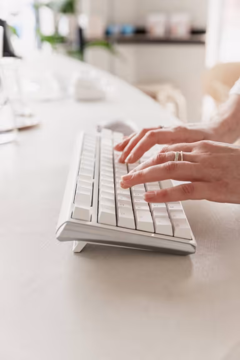Hands typing on a keyboard.