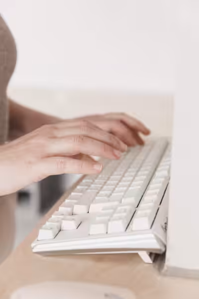 Hands typing on a keyboard.