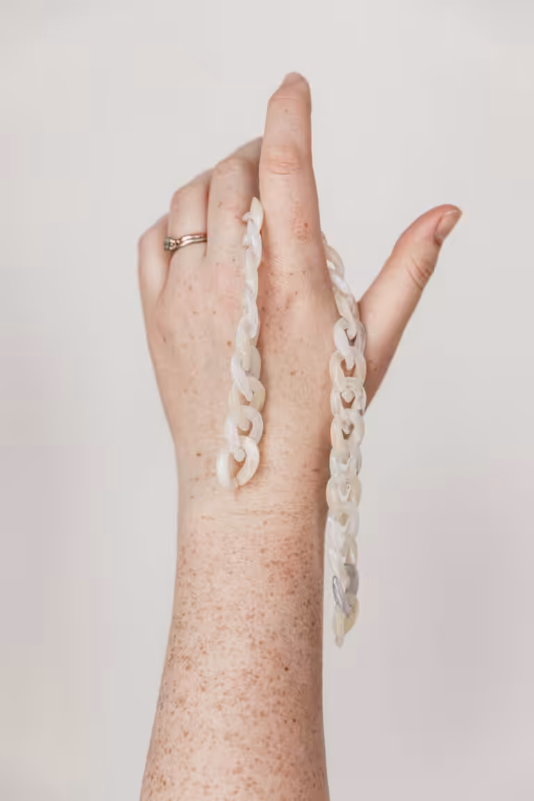 Studio Cotton Aime's hand holding up some links.