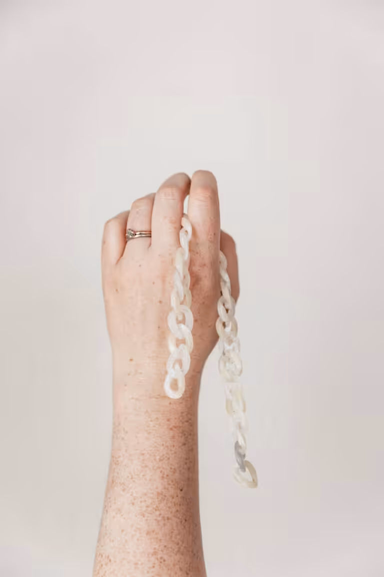 Studio Cotton Aime's hand holding up some links.