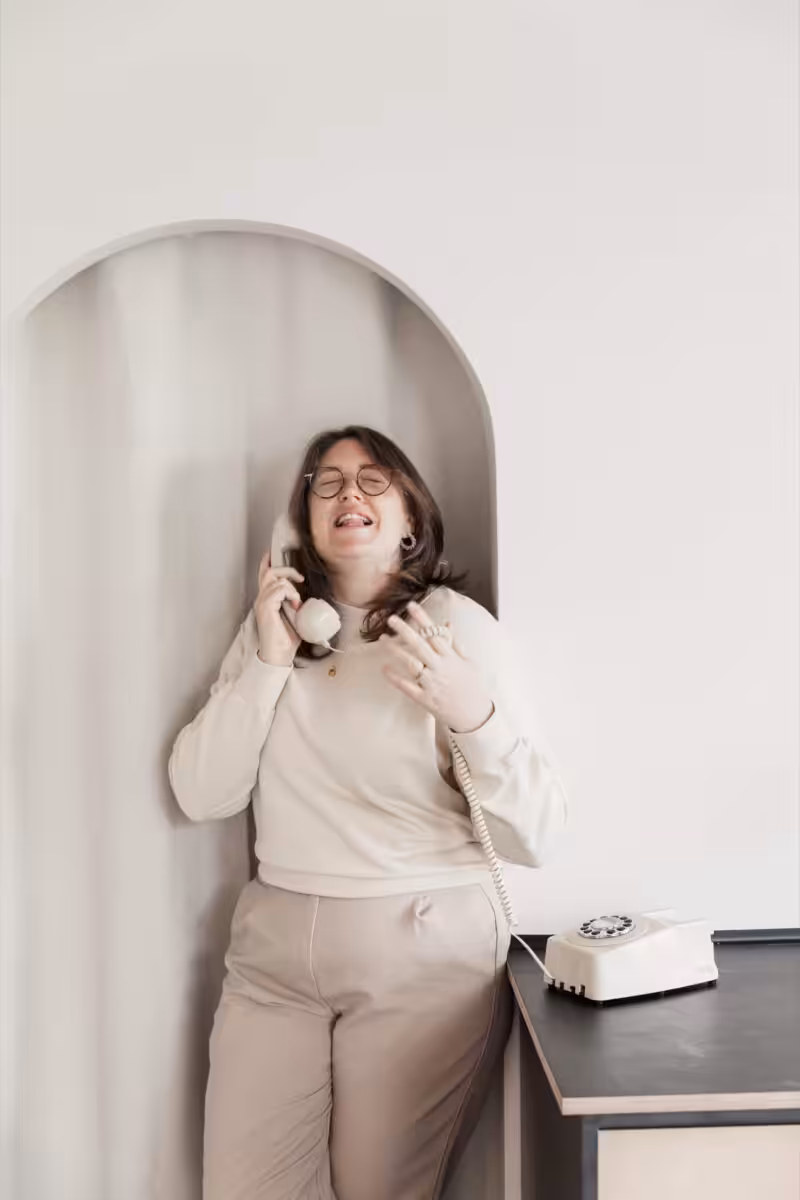 Aime from Studio Cotton talking on a retro dial telephone.