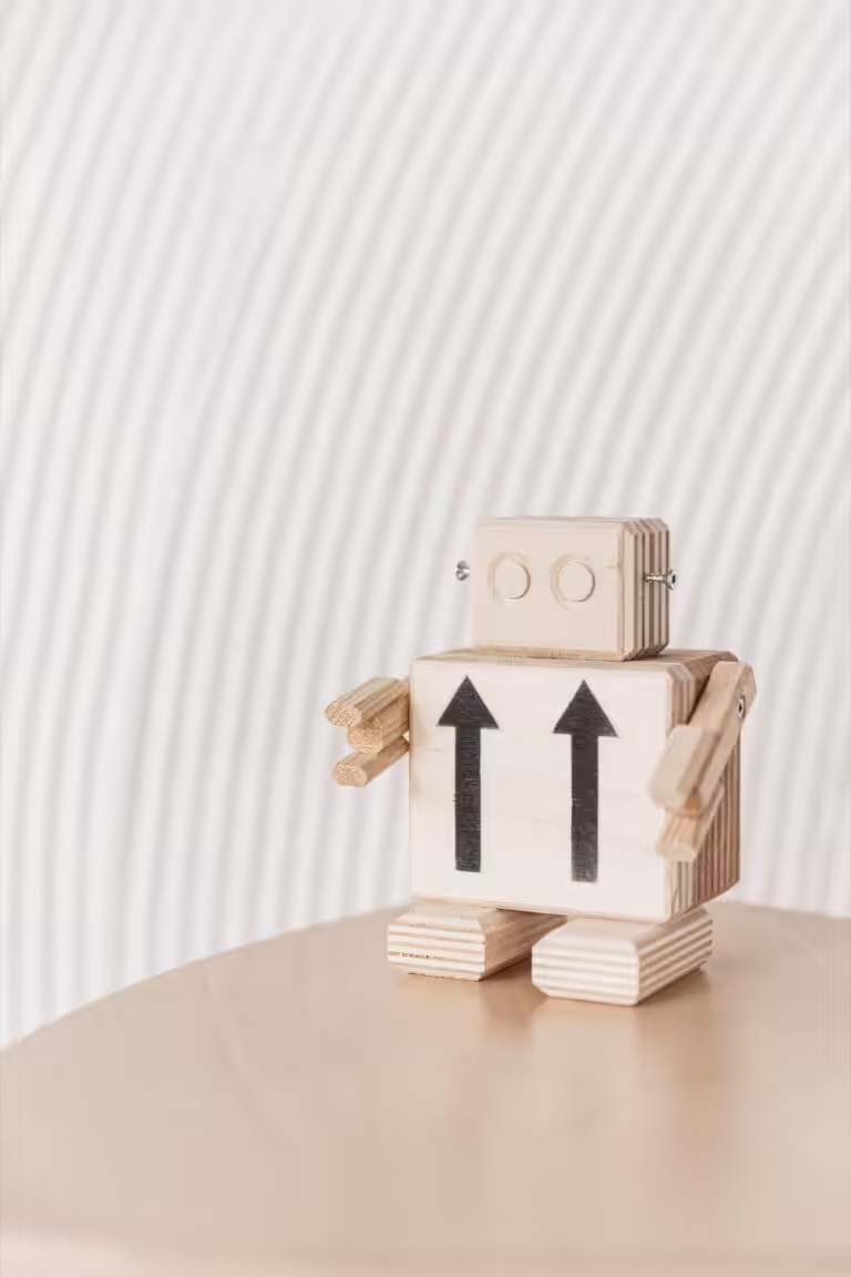 Wooden Robot placed on a wooden surface.