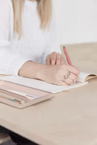 Writing notes with a pink pen.
