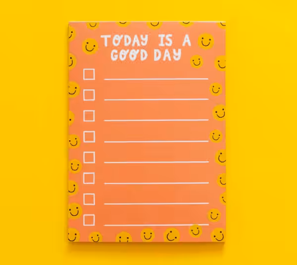 Orange notepad with yellow smiley faces and checklist. Reads, "today is a good day" at the top.