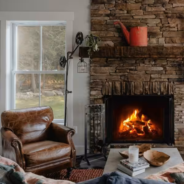 Living room with leather armchair and lit fire